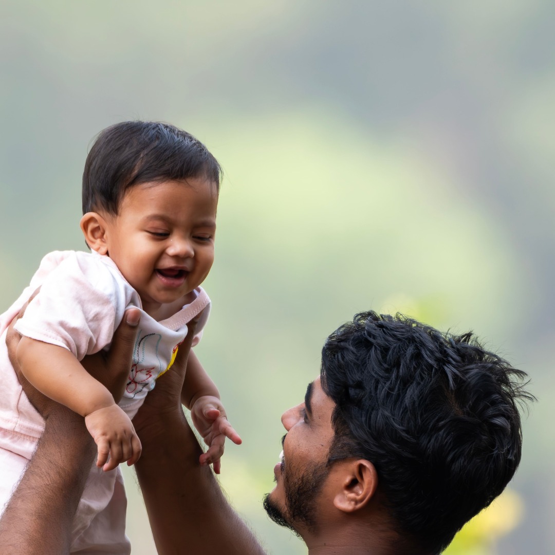 Parent and child smiling together in a warm, casual family dentistry setting.